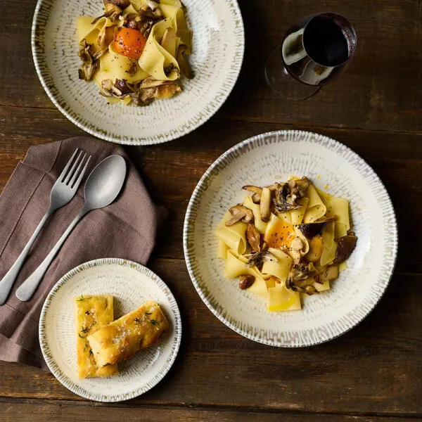 Pasta served in Churchill Cascade Taupe Coupe Plate and Coupe Bowls, arranged on a dark wooden table