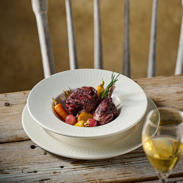 Churchill Inked Era White Wide Rim Bowl serving coq au vin as part of an elegant table setting